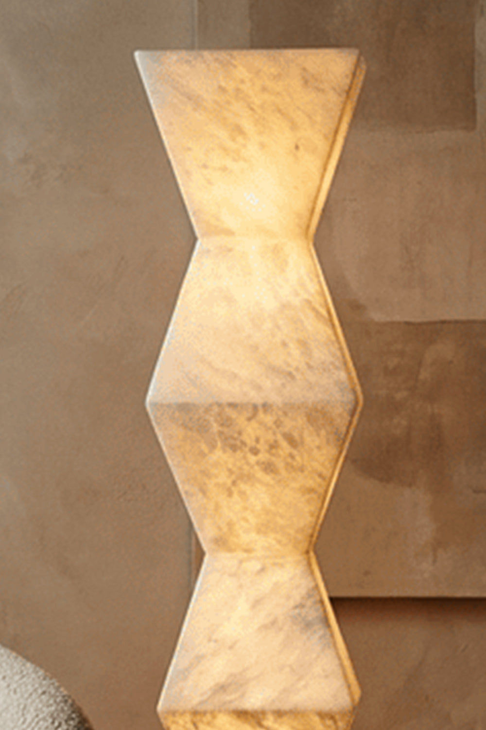 Kellan Geometric Alabaster Floor Lamp | Alabaster, Metal | Close-up focus on the stacked faceted geometric hourglass shapes of the lit translucent alabaster column showing unique veining | Detail shot | vexa lamps