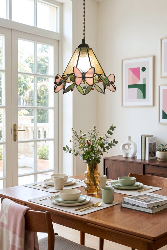 Mariposa Canopy Stained Glass Pendant Lamp | Glass, Metal | Single pendant light hanging over a wooden dining table decorated with green plants and tableware in a bright room | vexa lamps