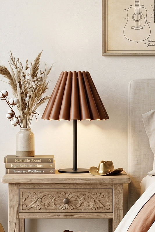Rowan Leather Pleated Table Lamp | Leather, Metal | Set on a carved vintage light wood nightstand next to dried pampas grass decor in a cozy bedroom | vexa lamps