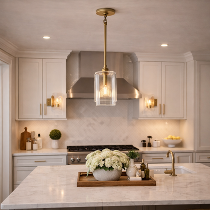 Modern kitchen with marble island, pendant light, and stainless steel appliances.