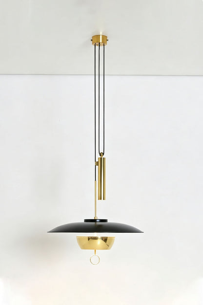 Adelaide Saucer Brass Pendant Light hanging from the ceiling with sleek black and gold design.