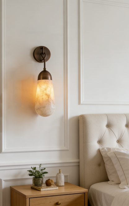 Alabaster Teardrop Wall Sconce illuminating a stylish bedroom with a light brown finish and natural alabaster design.