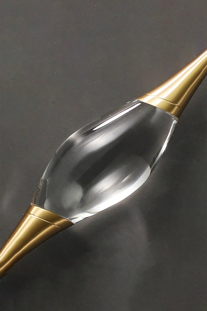 Astraea Crystal Linear Wall Sconce | Crystal, Brass | Macro close-up detail of the clear sculpted crystal core and the sleek gold brass conical holder on a dark background | Detail shot | vexa lamps