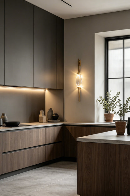 Astraea Crystal Linear Wall Sconce | Crystal, Brass | Installed as a luxury wall accent in a modern kitchen with dark matte cabinetry and a grey backsplash | vexa lamps