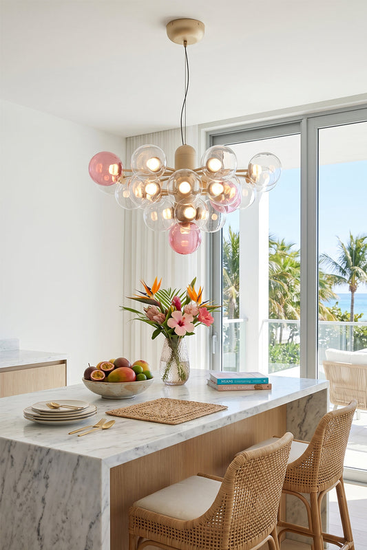 Astraea Prismatic Globe Chandelier | Glass, Metal | Suspended as a playful elegant centerpiece above a pristine white kitchen island counter with woven rattan bar stools in a coastal home | vexa lamps