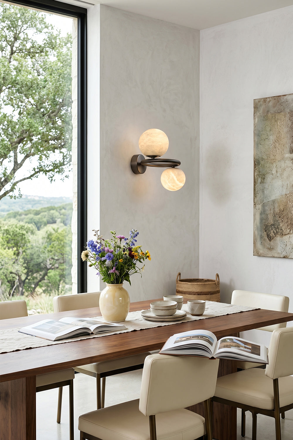Aura Two-Globe Alabaster Wall Sconce illuminated in a stylish dining area with modern decor.