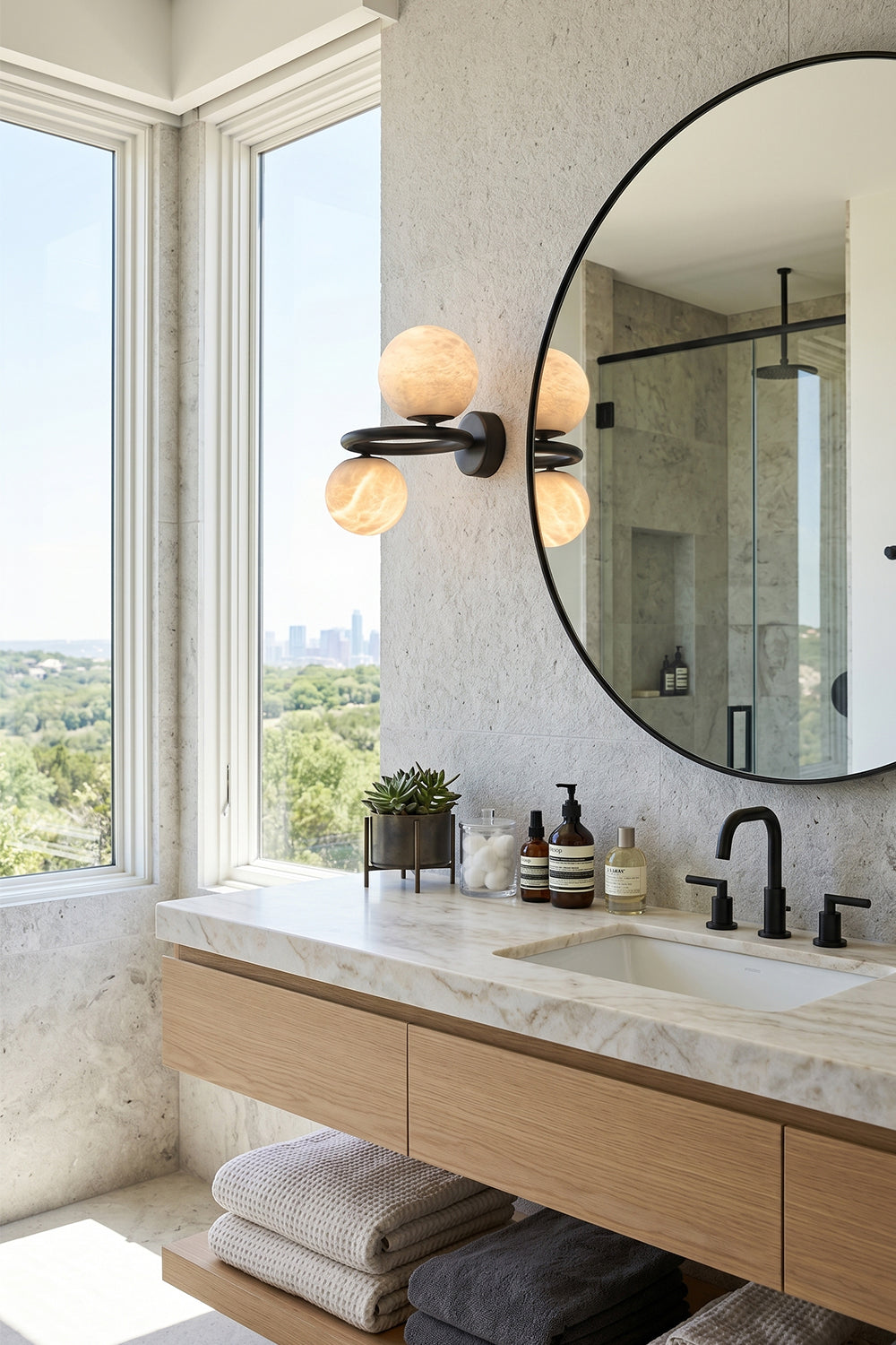Aura Two-Globe Alabaster Wall Sconce illuminating a modern bathroom with a stunning view.