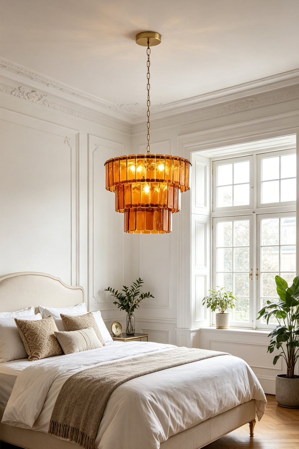 Aurelia Tiered Amber Glass Chandelier illuminating a cozy bedroom with warm, golden light.