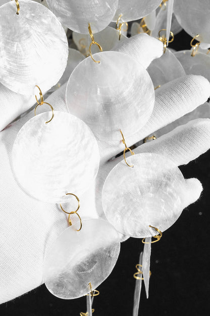 Aurelia Tiered Capiz Table Lamp | Capiz Shell, Metal | Texture close-up view of the delicate shimmering pearlescent capiz shell circles under bright light | Detail shot | vexa lamps