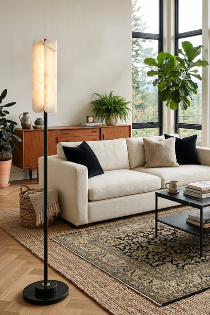Aurelius Alabaster Brass Floor Lamp | Alabaster, Brass | Positioned gracefully in a contemporary living room next to a cream fabric sofa, low coffee table, and a vintage patterned rug | vexa lamps