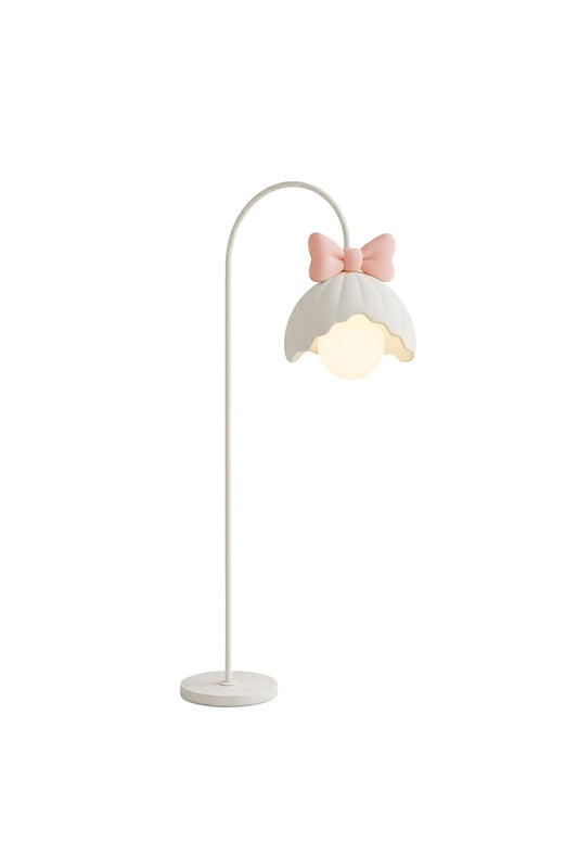 Bella Bow Arched Floor Lamp | Metal, Resin | Whimsical white arched gooseneck floor lamp featuring a scalloped flower lampshade topped with a pastel pink bow | Isolated lit product shot on white background | vexa lamps