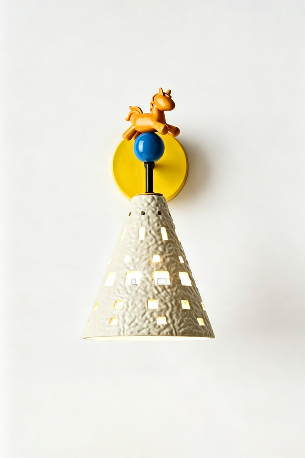 Carousel Horizon Ceramic Wall Sconce | Metal, Resin, Ceramics | Frontal view of the fully lit sconce against a plain wall, showing light filtering through the perforated shade | Isolated shot | vexa lamps