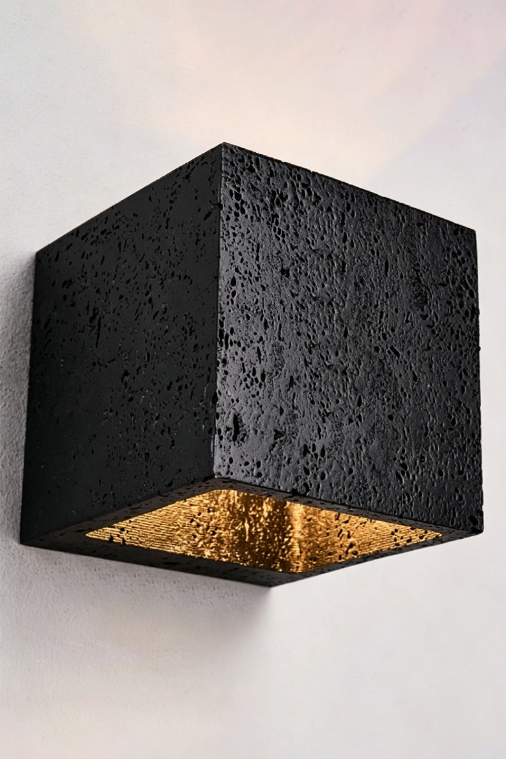 Celestial Tectonic Black Travertine Wall Lamp | Black Travertine | Lit lamp on neutral wall showing symmetric light beams | vexa lamps