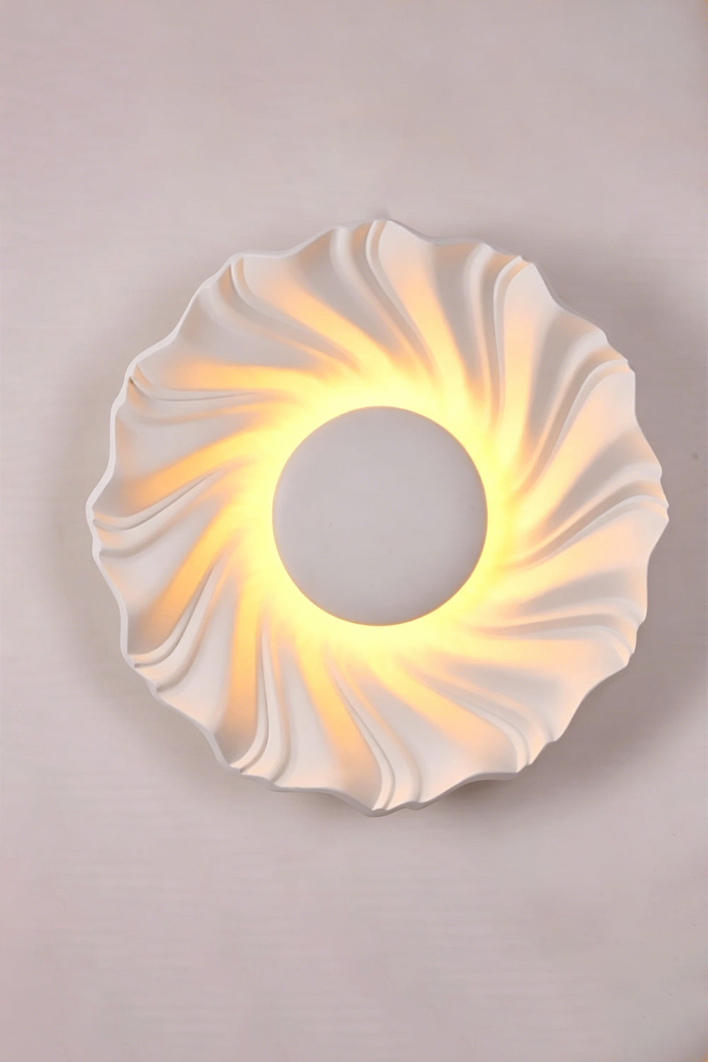 Centripetal Solstice Metal Wall Lamp | Metal, Resin | White textured lamp on a plain background, providing warm light | Isolated lit variant shot | vexa lamps