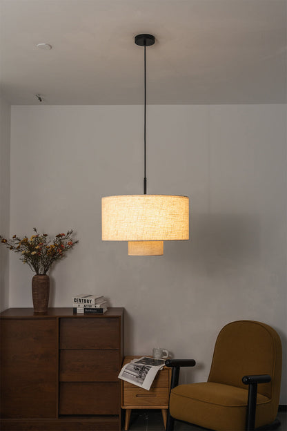 Concentric Veil Fabric Pendant Light | Fabric | Lit pendant near an armchair and wooden chest of drawers | vexa lamps