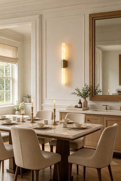 Corin Linear Alabaster Wall Sconce illuminating a modern dining room with natural decor and a large mirror.