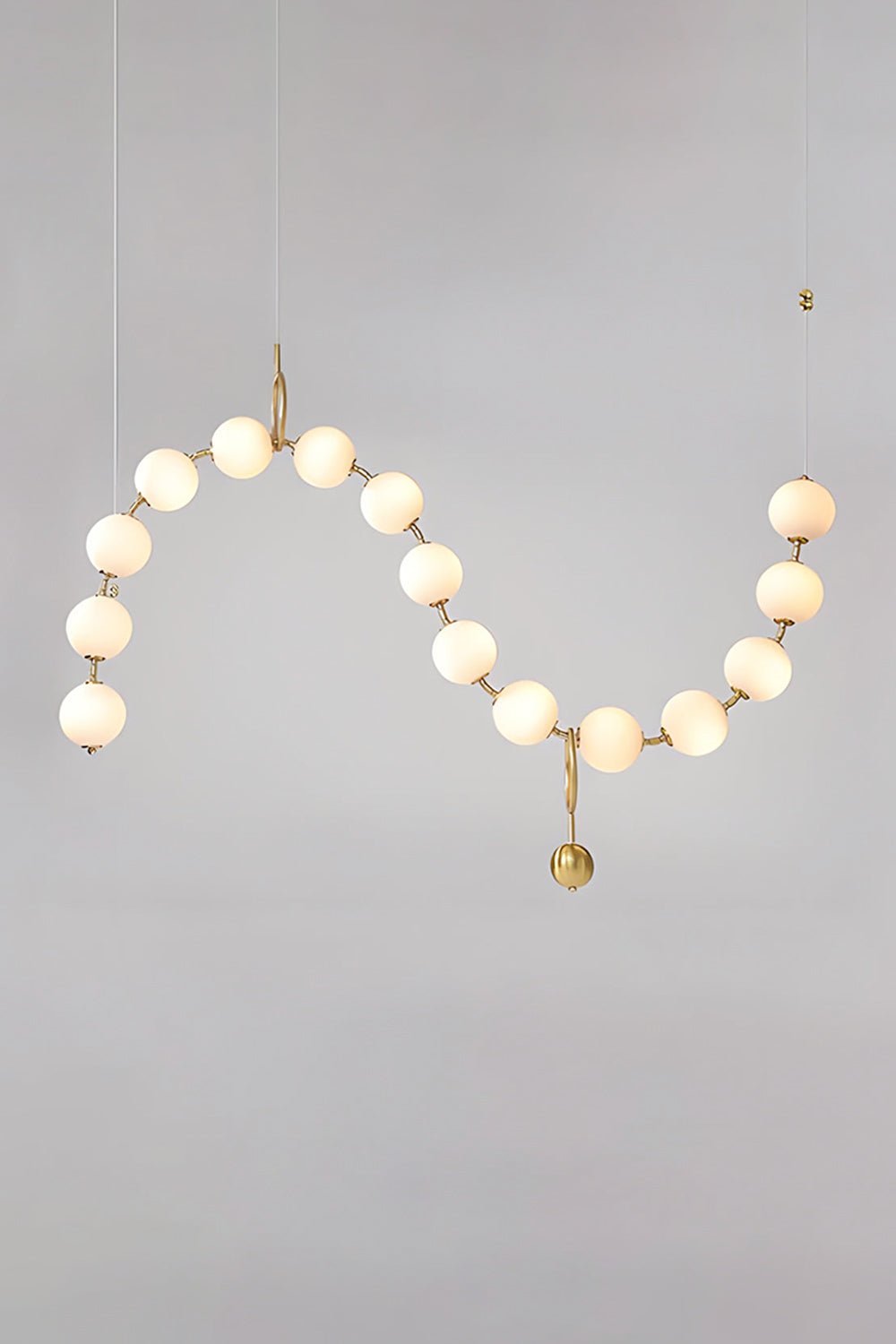 Delphine Pearl Strand Chandelier featuring matte-white globes and brass-toned chain for elegant lighting.