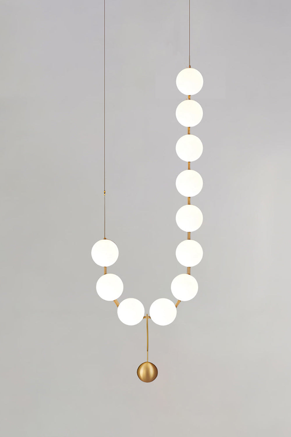 Delphine Pearl Strand Chandelier with matte-white globes and brass-toned details, perfect for elegant lighting.