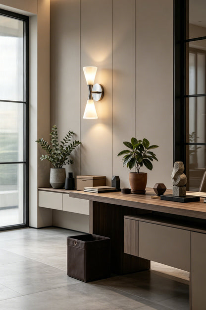 Diabolo Symmetry Glass Wall Sconce illuminating a modern workspace with plants and stylish decor.
