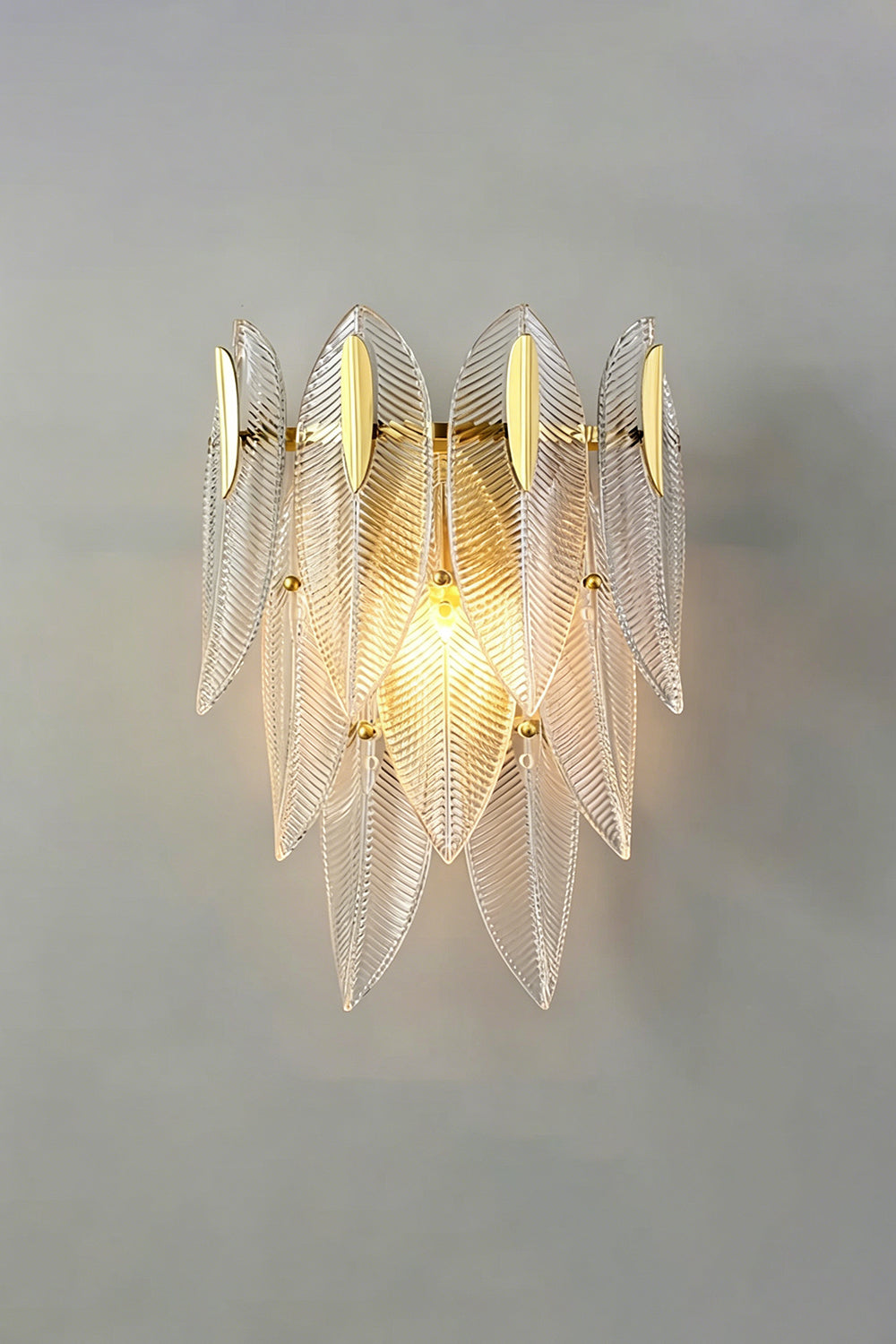 Elowen Cascading Glass Wall Lamp | Glass, Metal | Studio front view of the fully illuminated tiered glass fixture casting a warm, romantic ambient light halo on a grey backdrop | vexa lamps