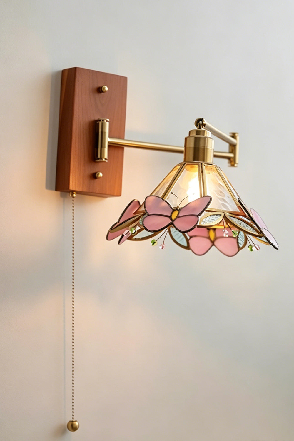 Iris Butterfly Stained Glass Wall Lamp | Stained Glass, Metal, Wood | Frontal perspective view of the fully illuminated stained glass wall lamp casting a soft warm backlight halo against a plain neutral wall | vexa lamps
