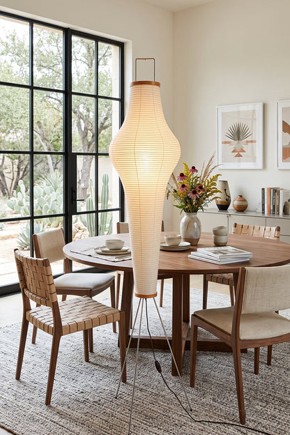 Isolde Ribbed Paper Column Floor Lamp illuminating a modern dining space with wooden furniture.