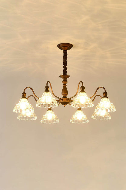 Isolde Vintage Scalloped Glass Chandelier | Warm Halo Effect | Staged studio shot of the illuminated glass chandelier projecting a beautiful golden light pattern onto a warm cream wall | vexa lamps