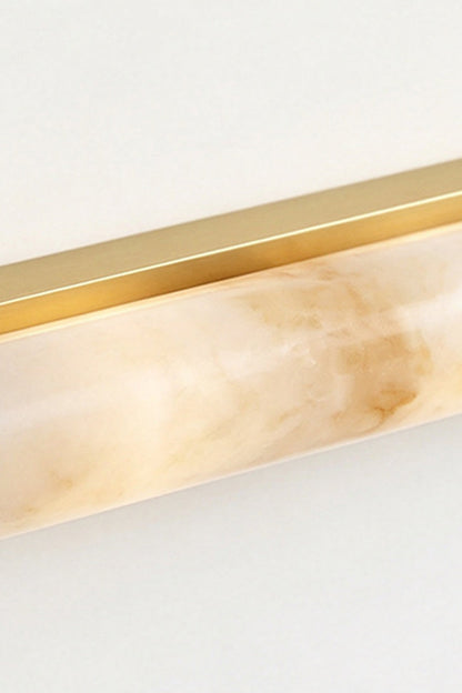 Kester Alabaster Tube Wall Sconce showing a natural alabaster shade with a curved gold metal frame.