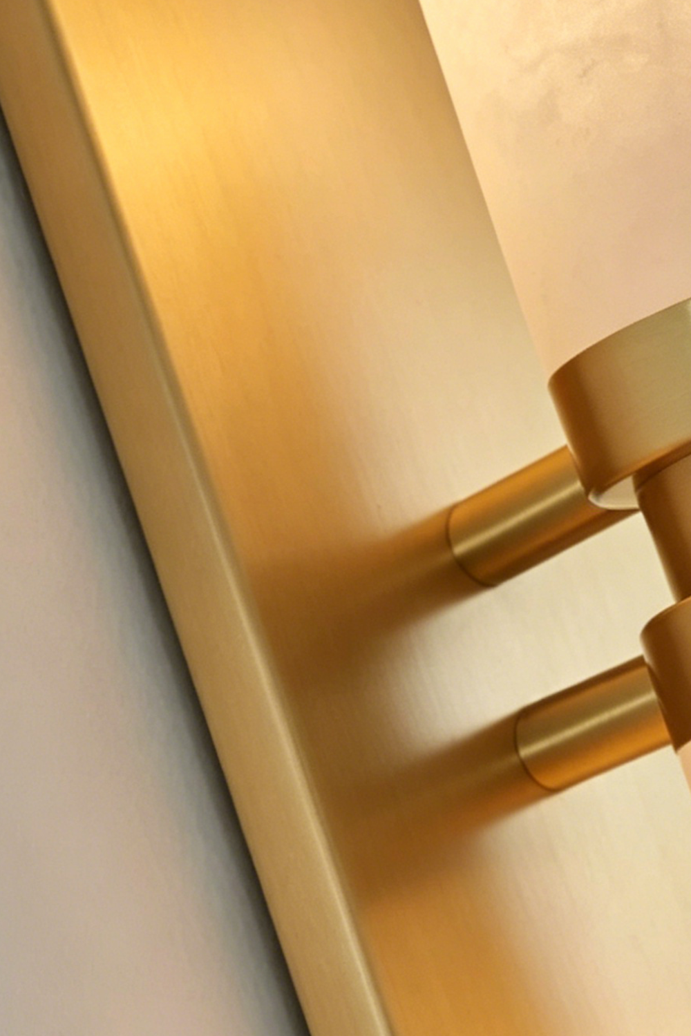 Linea Alabaster Capsule Wall Sconce | Alabaster, Brass | Macro close-up focus on the premium brushed gold brass metallic backing and mount hardware | Detail shot | vexa lamps