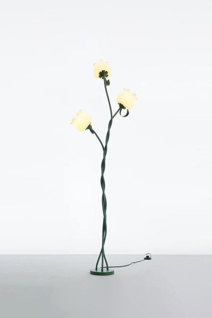 Linnea Tulip Bloom Floor Lamp | Glass and Green Metal | Full standing view glowing softly in a studio setting against a plain wall | vexa lamps