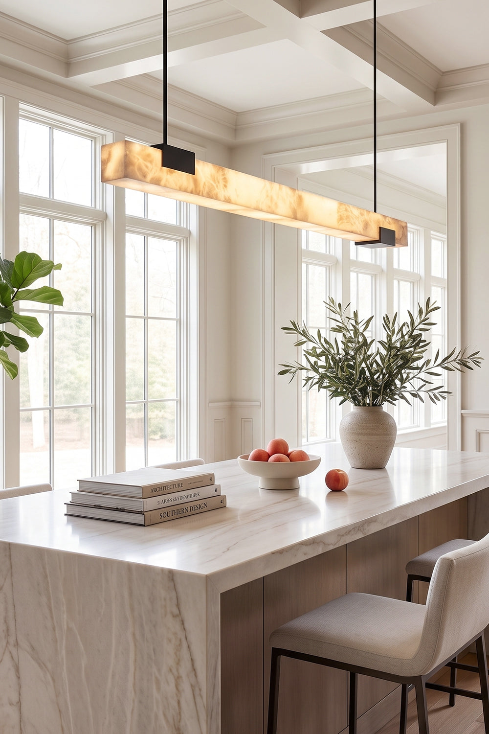 Liora Linear Alabaster Pendant Light | Natural Alabaster and Black Metal | Illuminating a modern white marble kitchen island bar counter with high ceiling windows | vexa lamps