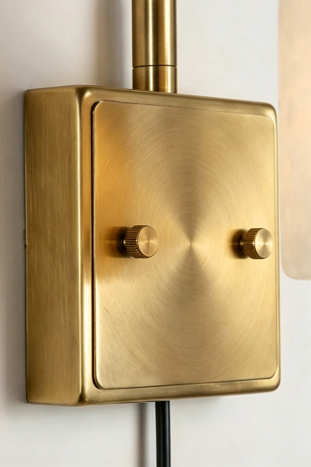 Liora Scalloped Alabaster Wall Sconce | Natural Alabaster and Brushed Brass | Detailed close-up view highlighting the smooth texture and screws of the rectangular brass mounting plate | vexa lamps