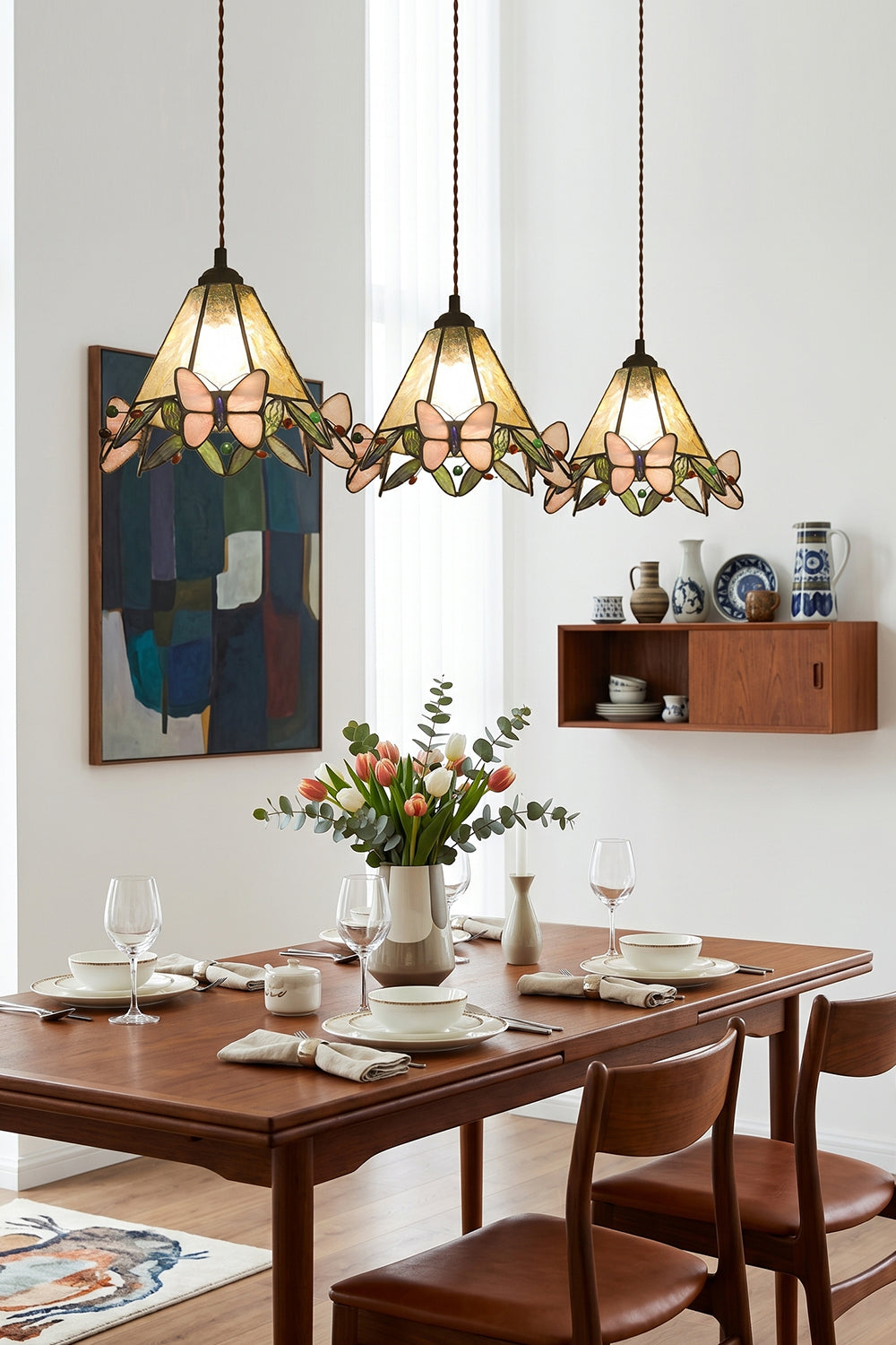 Mariposa Canopy Stained Glass Pendant Lamp | Glass, Metal | A row of three matching stained glass pendants suspended over a long dark wood dining table and chairs | vexa lamps