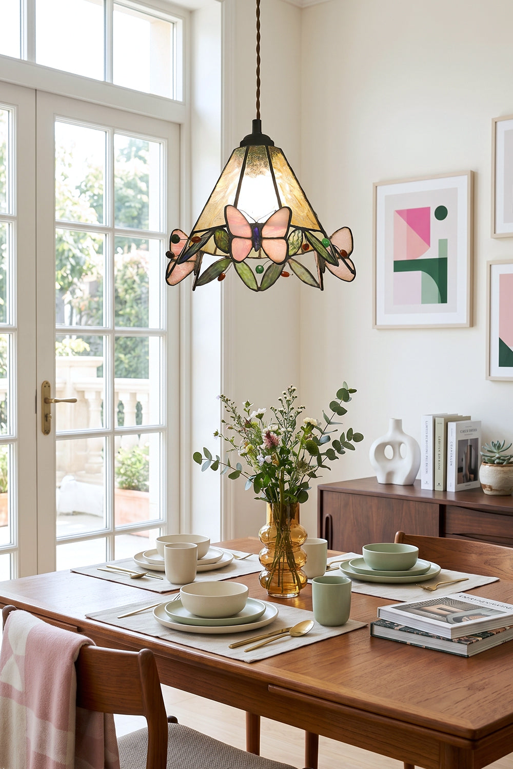 Mariposa Canopy Stained Glass Pendant Lamp | Glass, Metal | Single pendant light hanging over a wooden dining table decorated with green plants and tableware in a bright room | vexa lamps