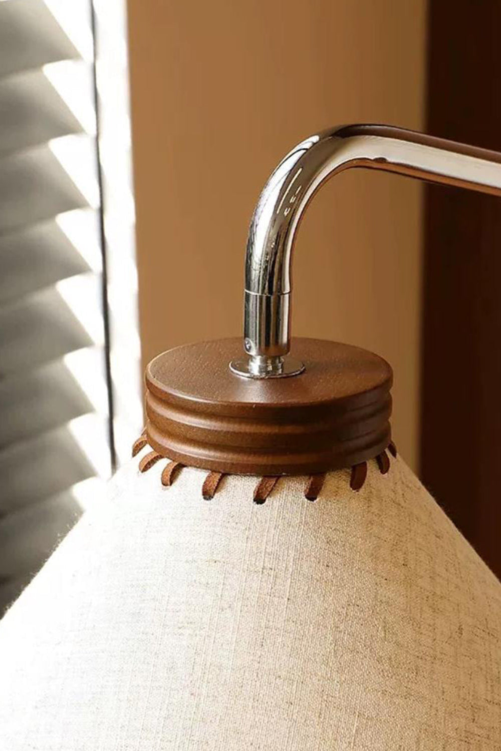 Marlowe Angled Linen Reading Floor Lamp | Linen, Wood, and Chrome Metal | Extreme close-up shot of the curved chrome pipe neck inserting into the dark wood trim atop the shade | vexa lamps