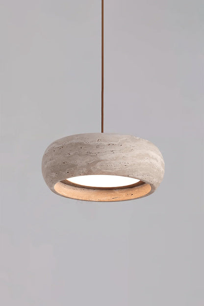 Maro Travertine Donut Pendant Light | Travertine, Metal | Studio product view of the fully illuminated travertine donut pendant light casting a cozy golden halo on a grey background | vexa lamps