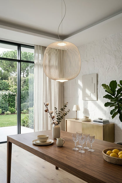 White elliptical wire cage lamp near large window | Aluminum | Bright dining room interior with wooden furniture | vexa lamps