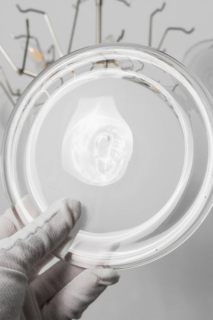 Mirella Circular Glass Pane Ceiling Light | Glass Pane Detail | Close-up shot showing a white-gloved hand holding an individual circular frosted white glass disc plate component | Detail shot | vexa lamps