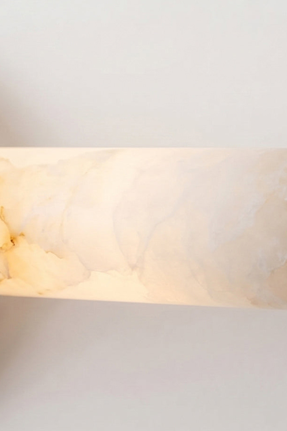 Nerida Linear Alabaster Wall Sconce | Alabaster, Brass | Macro view of the fully illuminated translucent natural white alabaster stone cylinder showcasing its rich cloudy mineral veining | Detail shot | vexa lamps