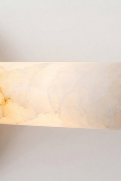 Nerida Linear Alabaster Wall Sconce | Alabaster, Brass | Macro view of the fully illuminated translucent natural white alabaster stone cylinder showcasing its rich cloudy mineral veining | Detail shot | vexa lamps
