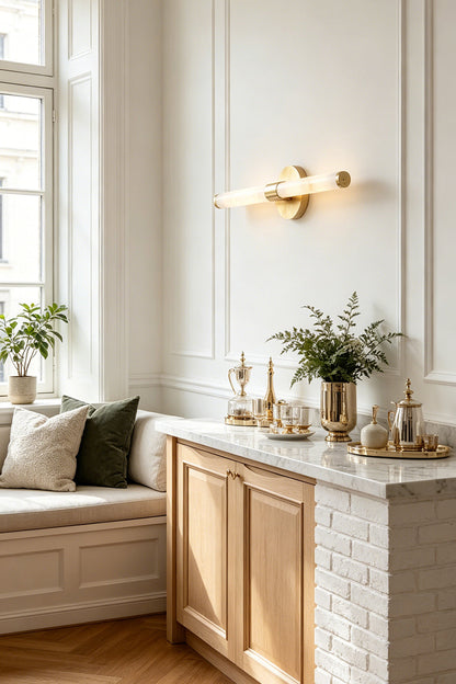 Nerida Linear Alabaster Wall Sconce | Alabaster, Brass | Positioned elegantly on a white paneled wall above a classic wooden sideboard cabinet with a marble top in a sunlit hallway lounge | vexa lamps