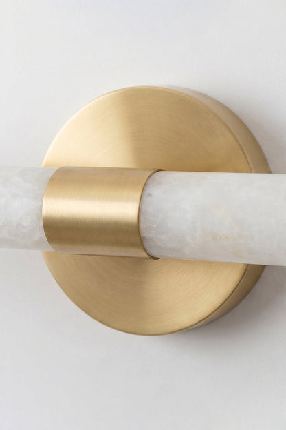 Nerida Linear Alabaster Wall Sconce | Alabaster, Brass | Detailed close-up shot focusing on the central circular brushed gold brass wall mounting plate and ring clamp holding the alabaster bar | Detail shot | vexa lamps