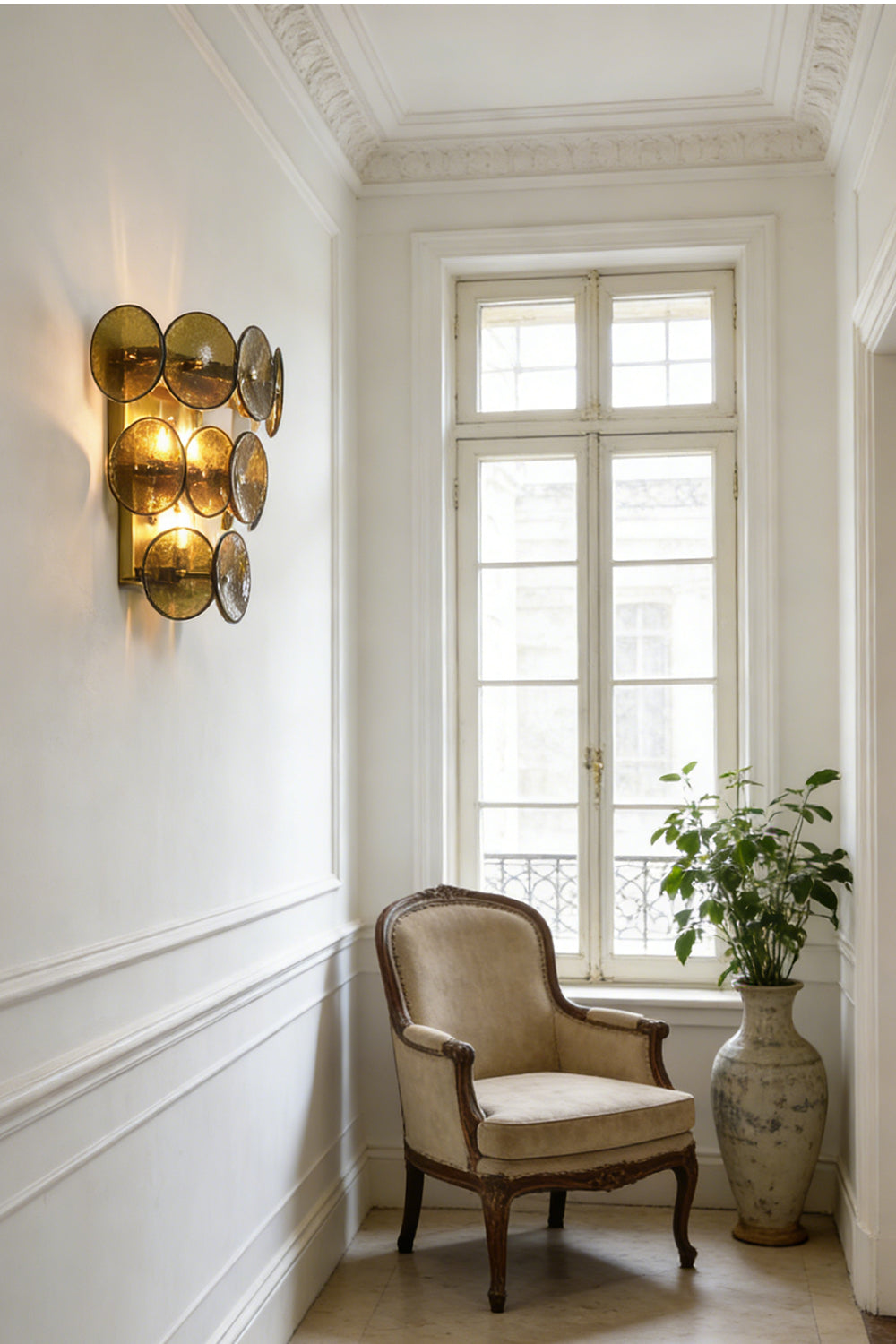Lit tiered olive green glass disc lamp | Metal, Glass | Installed in a corner near a wicker basket | vexa lamps
