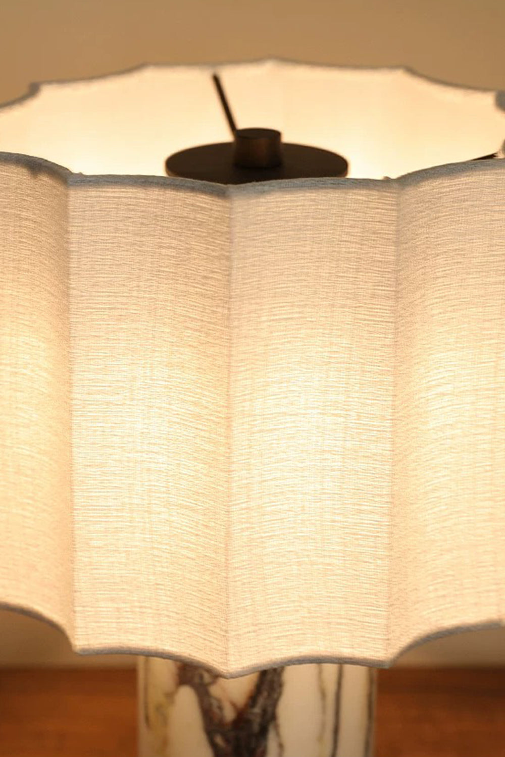 Orbis Veil Pleated Marble Table Lamp with a softly lit pleated fabric shade showcasing its elegant design.