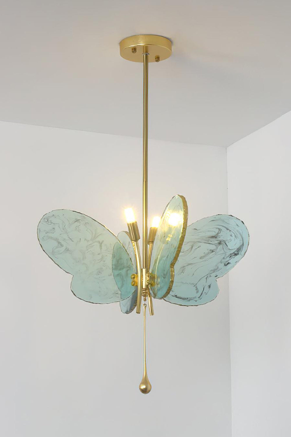 Papillon Glass Butterfly Pendant Lamp | Glass, Metal | Front view of the fully lit blue glass butterfly variant radiating soft ambient light against a neutral studio wall | vexa lamps
