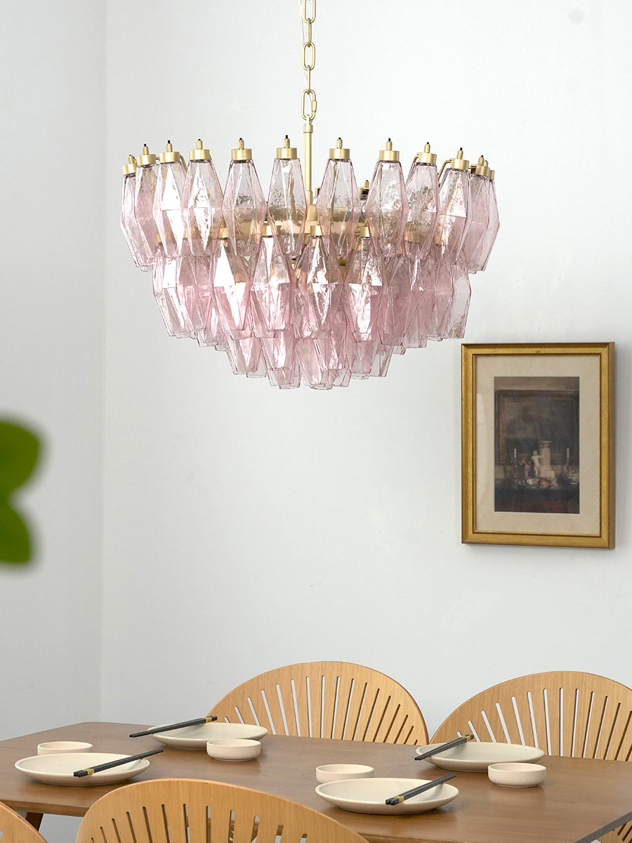 Modern pink glass tiered pendant light | Metal, Glass | Centered in a dining room with white walls and wood furniture | vexa lamps