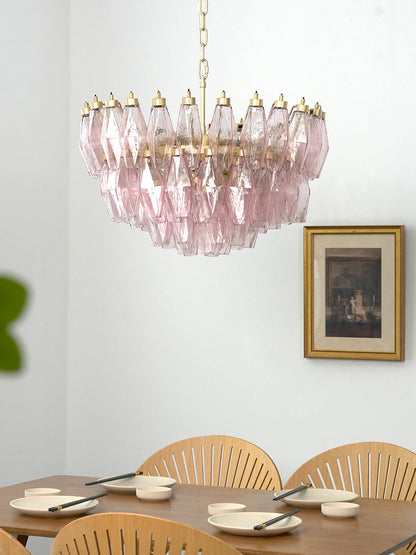 Modern pink glass tiered pendant light | Metal, Glass | Centered in a dining room with white walls and wood furniture | vexa lamps