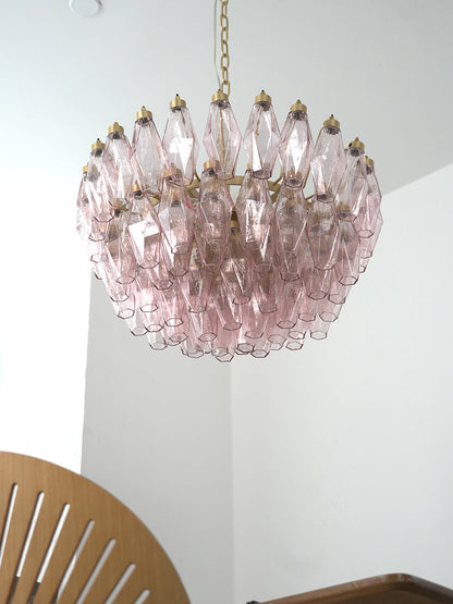 Pink art glass tiered chandelier in a modern hallway | Metal, Glass | High-ceiling installation over a corner seat | vexa lamps