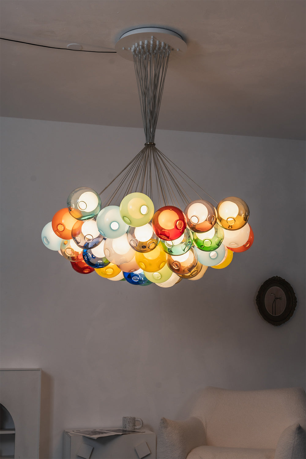 Rainbow Glass Bubble Cluster Chandelier | Glass, Metal | Atmospheric view of the chandelier fully lit in a dark room, showcasing the vibrant glowing colors of the glass spheres | vexa lamps