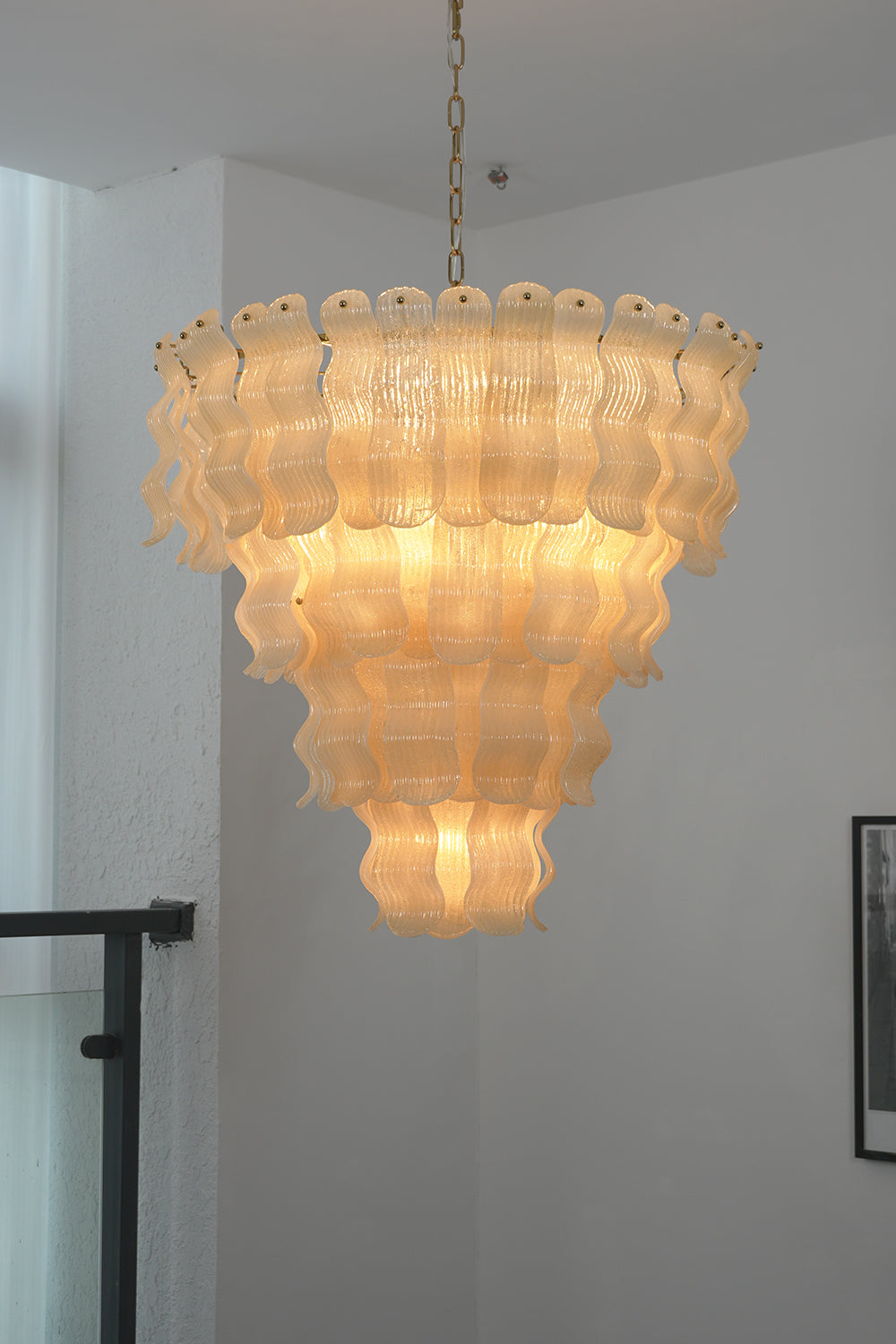 Multi-tier ruffled glass chandelier | Metal | Glass | Hanging in a modern interior near a staircase railing | vexa lamps